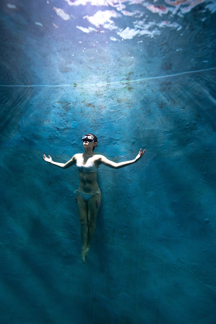 Female Swimming In Blue Water In Pool