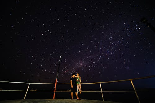 Couple embracing against starry sky at night