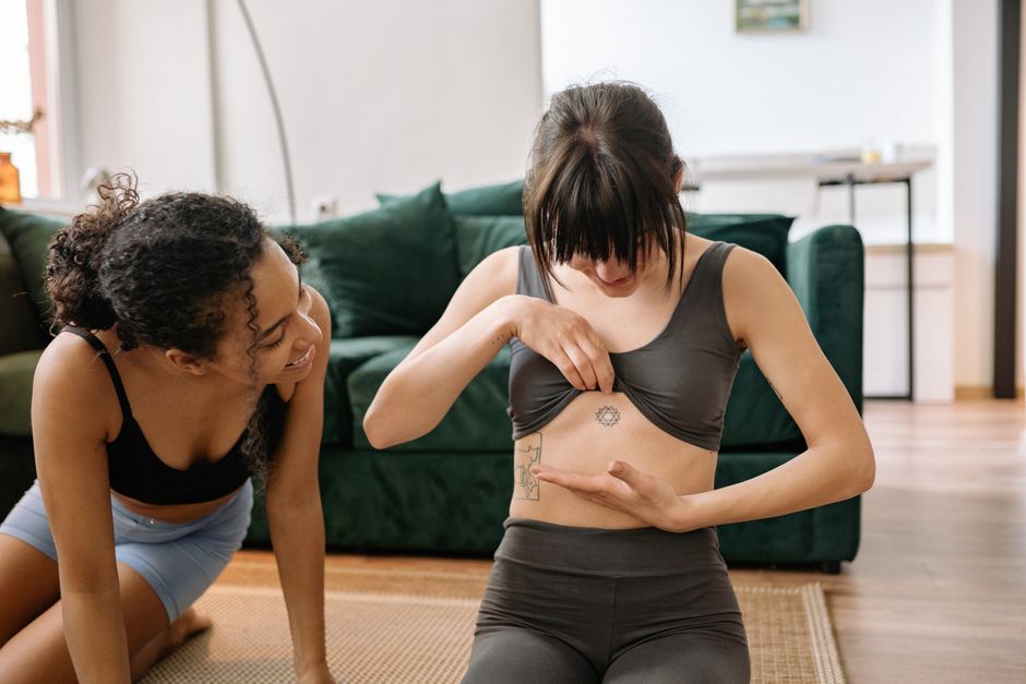 Two women practicing yoga indoors, highlighting fitness and friendship.