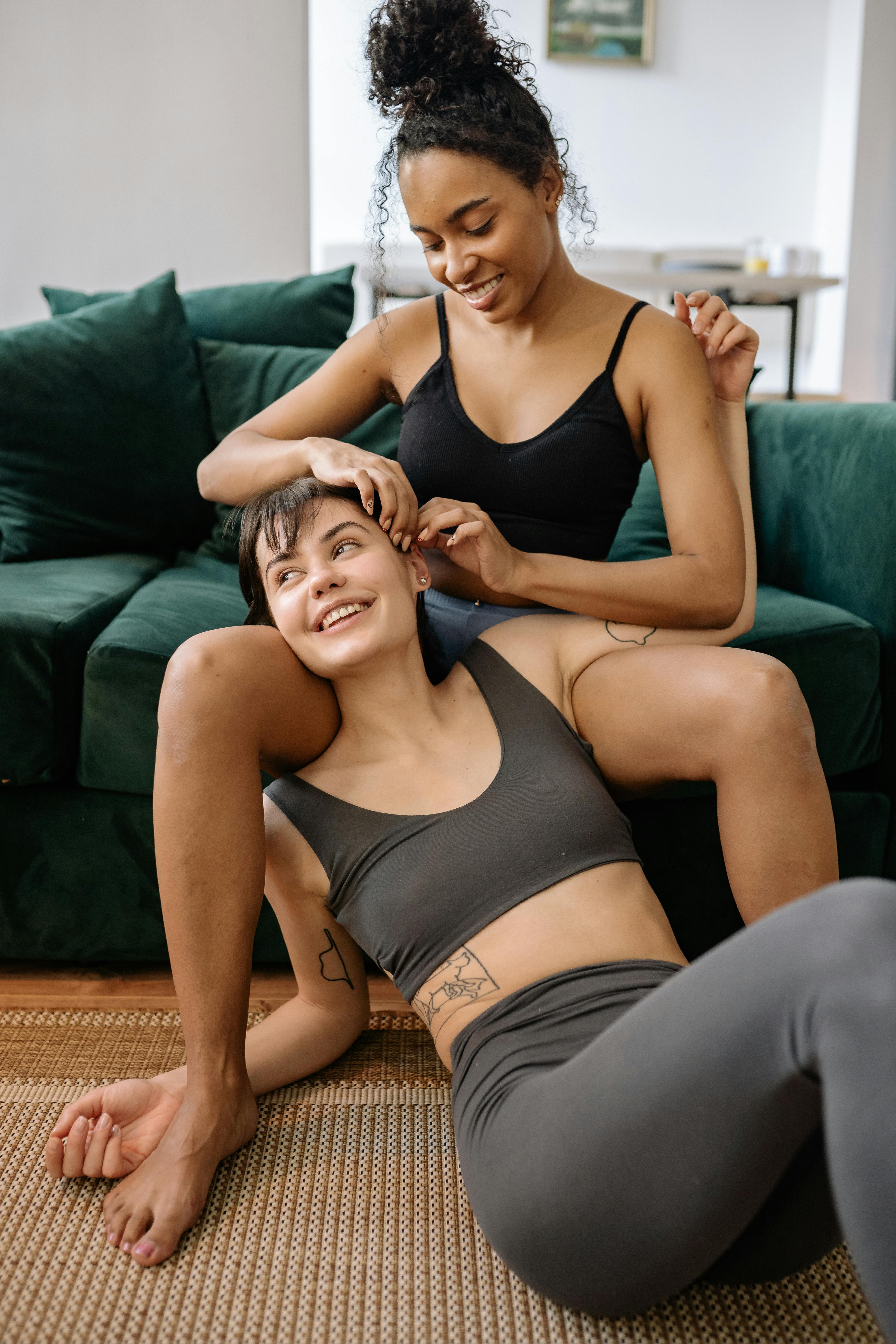 woman in black tank top and gray shorts sitting on brown carpet