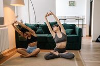 Woman in Black Sports Bra and Black Leggings Doing Yoga on Black Couch
