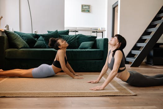 Two young women doing yoga at home, enjoying relaxation and fitness.