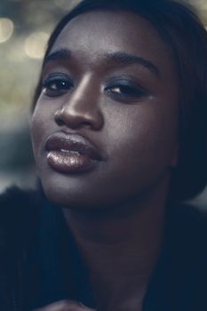 Close-up portrait of a stylish woman with makeup and glossy lips.