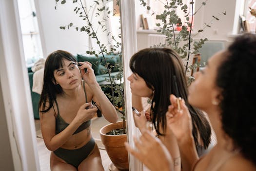 Two women applying makeup in a Paris apartment with a mirror reflection and houseplants.