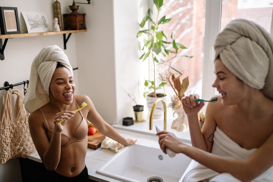 A joyful couple enjoying a morning routine, brushing teeth together indoors.