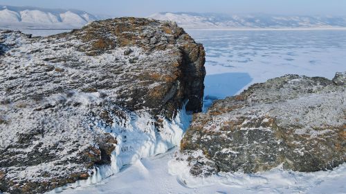 Free Aerial view of snow-covered cliffs and frozen Lake Baikal in winter, Olkhon Island, Russia. Stock Photo