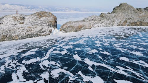 Rocky Mountain Covered With Snow Near Frozen Lake