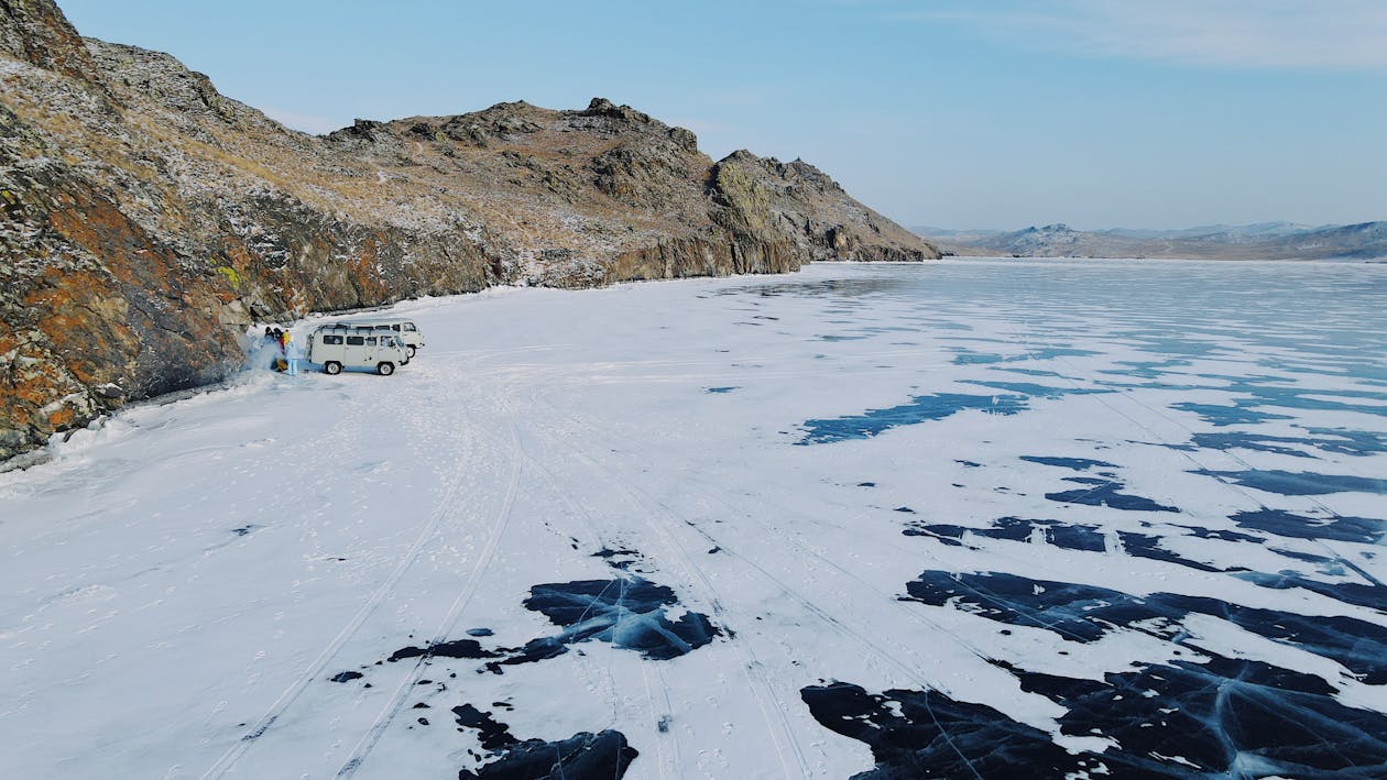 Cars on the Frozen Lake Near Rock Formation