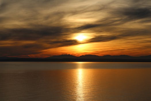 Captivating sunrise over ocean with dramatic clouds and golden reflections.