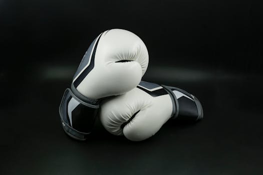 Close-up of black and white boxing gloves on a dark background, perfect for sports themes.