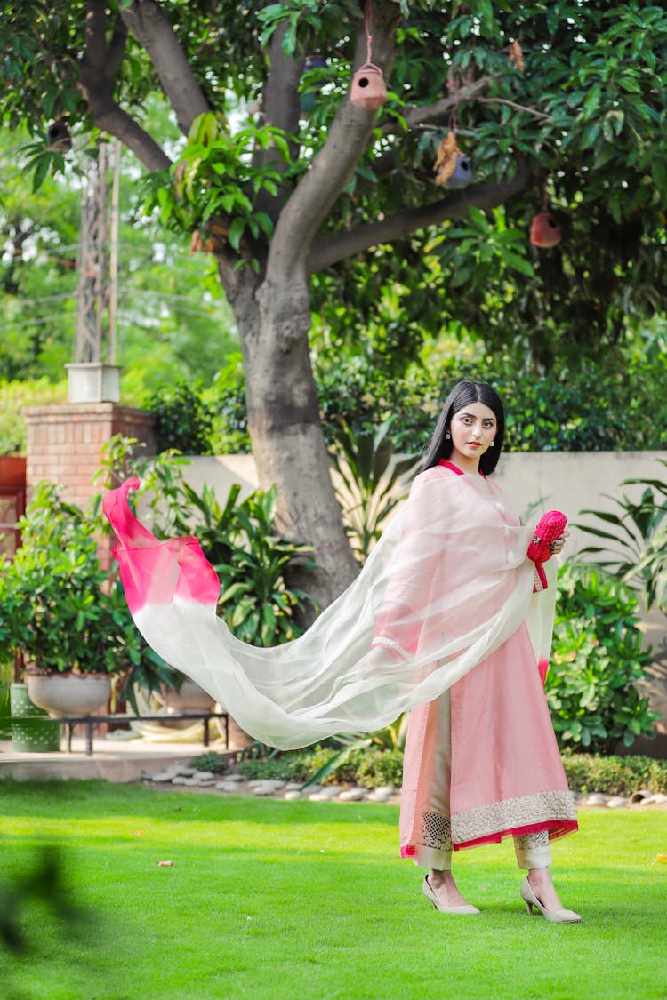 Beautiful Woman Walking In Garden With Long Scarf