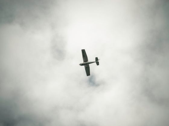 A small aircraft flying low through heavy cloud