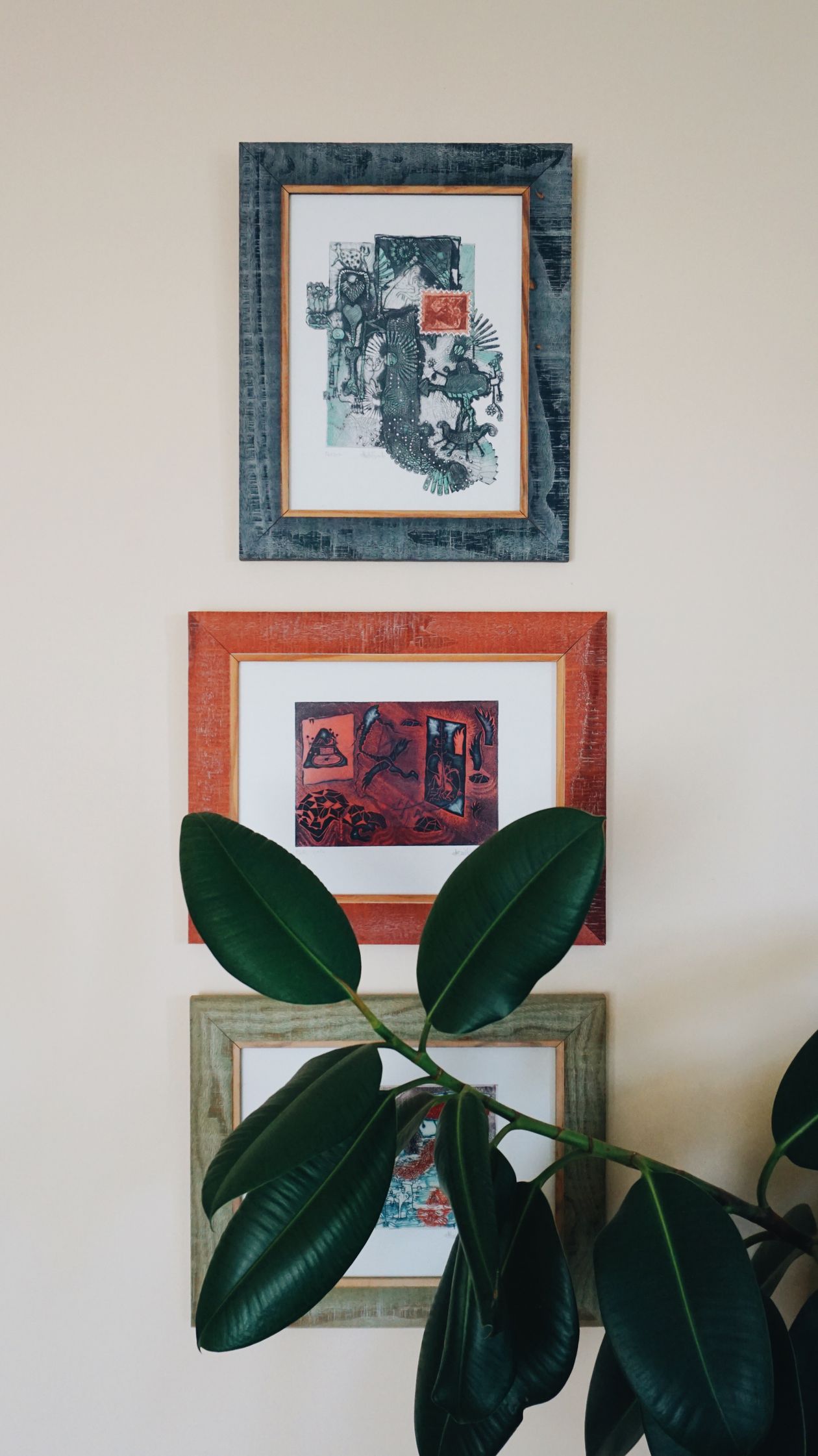 how to style a gallery wall: three framed artworks with a lush houseplant
