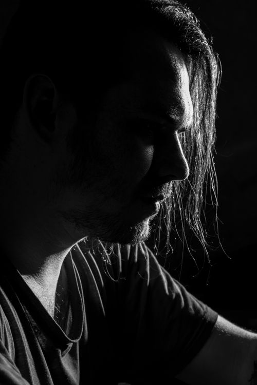Free Expressive monochrome portrait capturing the contemplative profile of a man in low-key lighting. Stock Photo
