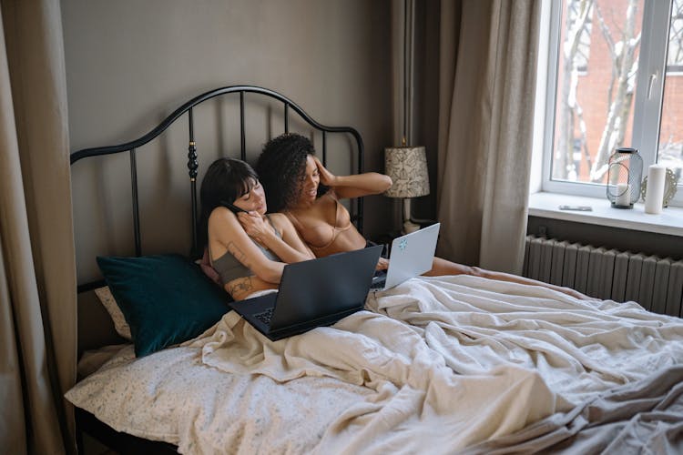 Women Working From Home While Sitting In Bed