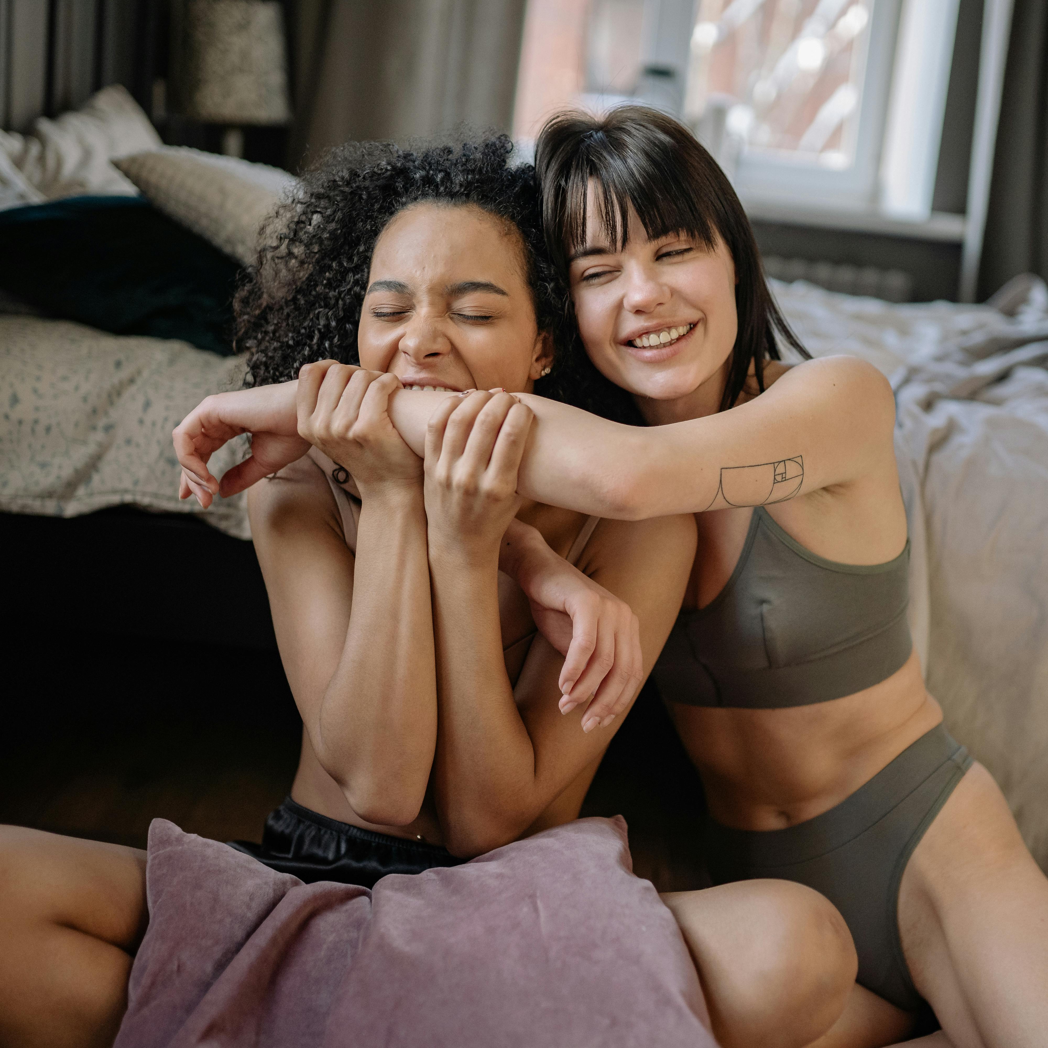 A Woman in a Black Sports Bra Sitting on the Bed · Free Stock Photo