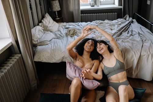 Free A happy couple enjoying a moment together in a cozy bedroom setting, capturing love and relaxation. Stock Photo