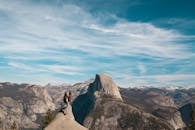 一名妇女和一名孩子站在优胜美地半圆顶上，俯瞰着壮丽的山脉景色