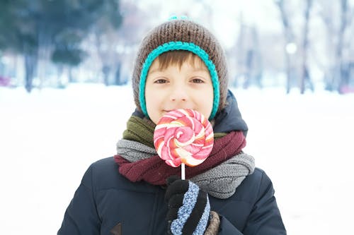 Boy Wearing Blue Jacket Eating Lollipop 