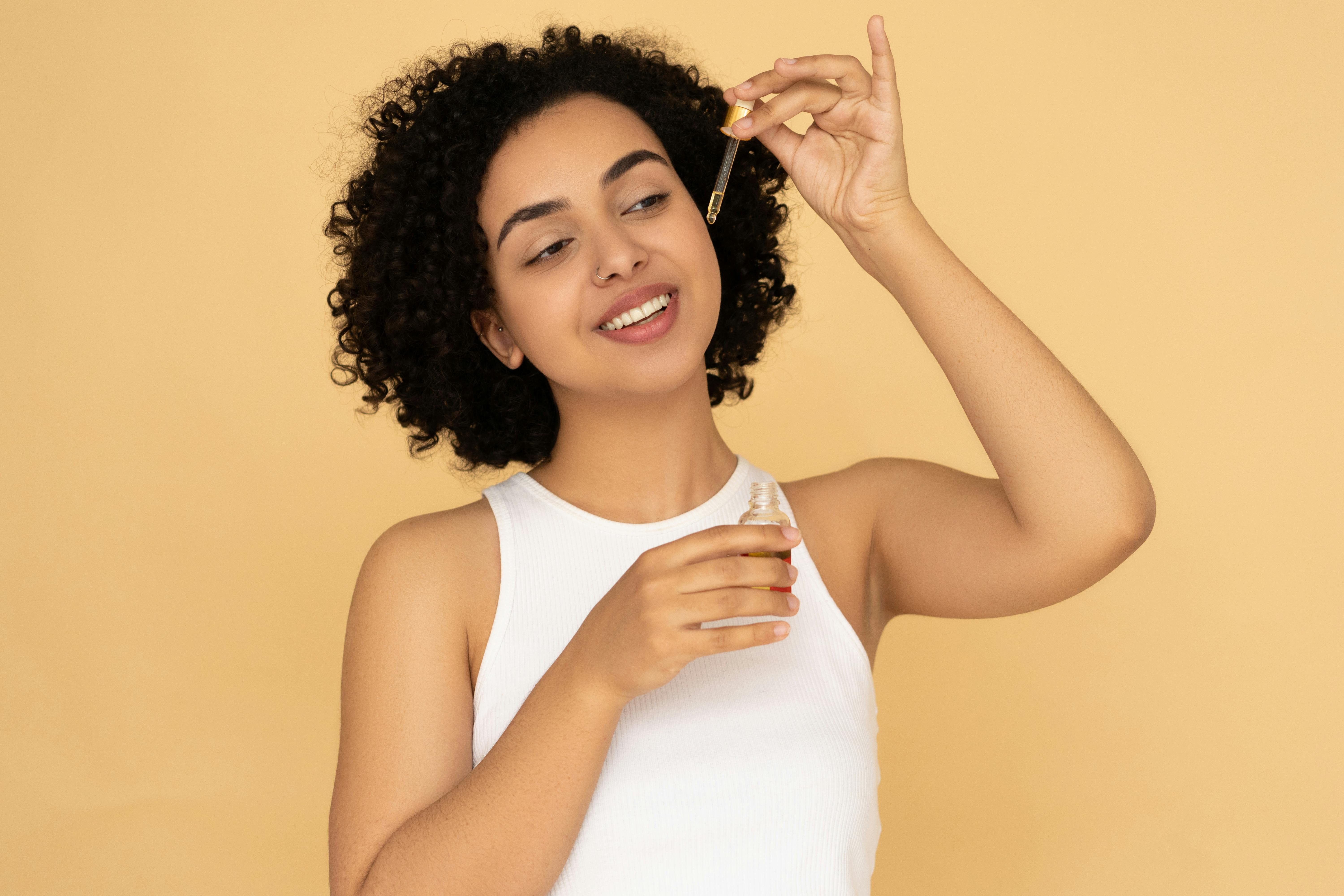 Free Woman in White Tank Top Holding A Bottle Stock Photo