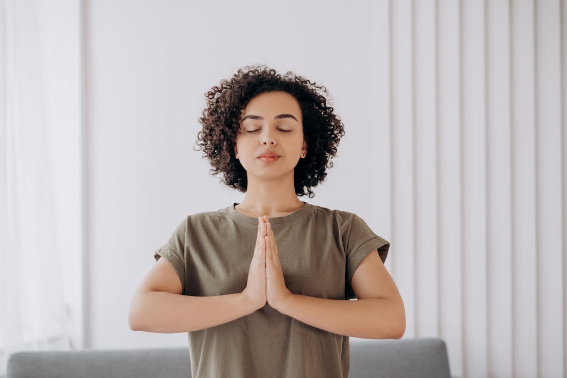 woman meditating in front of wall 
