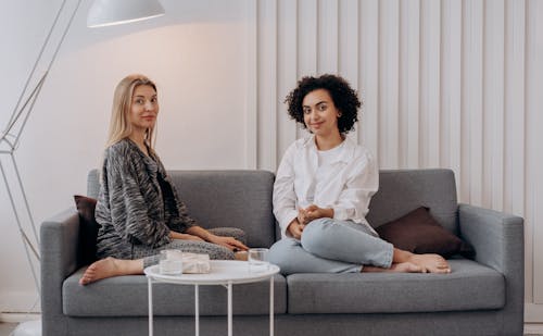 Free Two Women Sitting on Gray Couch Stock Photo