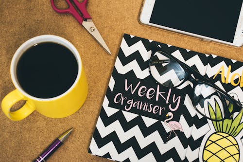 Tasse à Café En Céramique Jaune Et Blanche Sur Une Surface En Bois Marron Avec Des Lunettes Noires