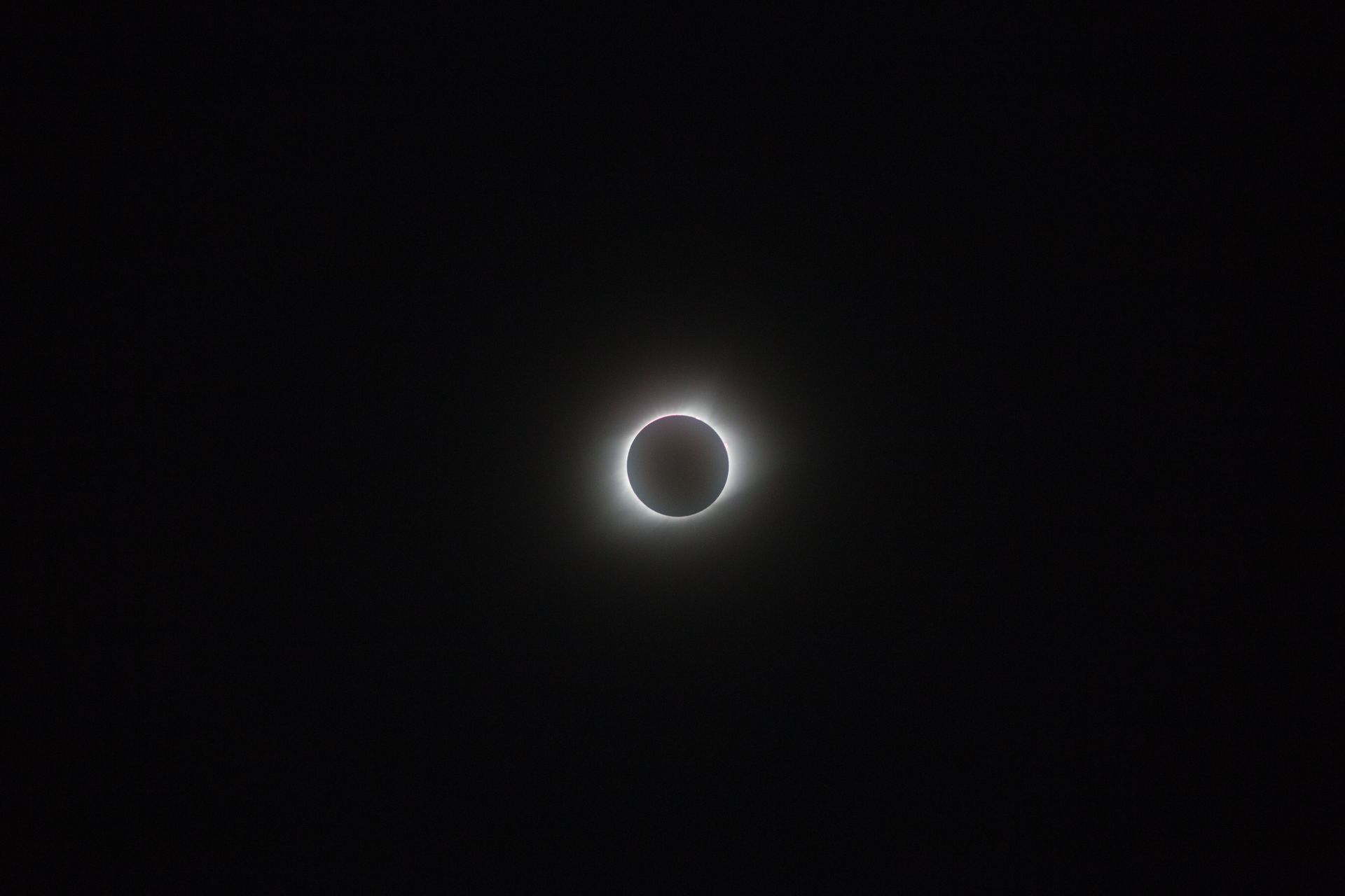 Captivating image of a solar eclipse with a glowing corona against the dark sky.