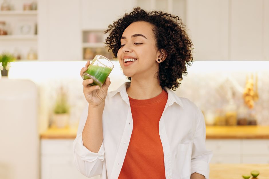 woman drinking green smoothie morning