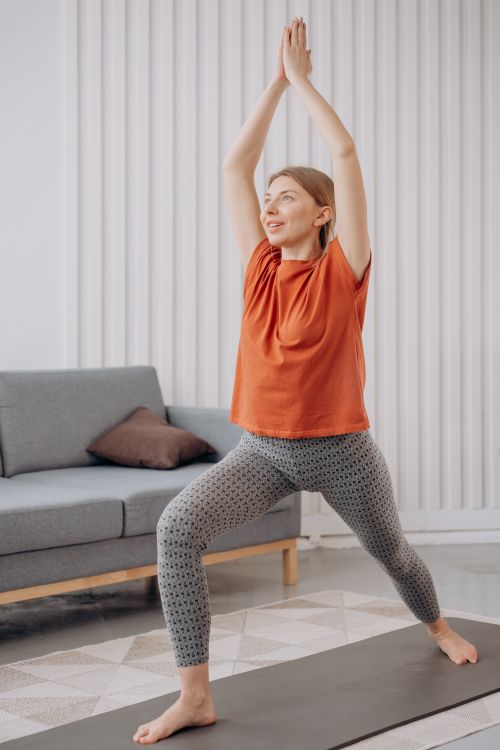 Free Adult woman doing yoga at home for mindfulness and healthy living. Stock Photo