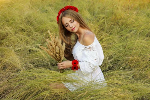 Woman in Red Flower Crown Holding a Bunch of Pampas Grass