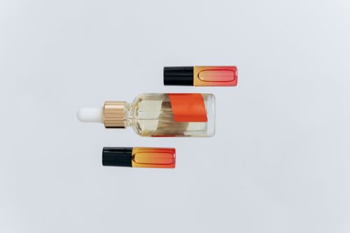 Free Minimalist flat lay of essential oil bottles with a pipette on a white background, perfect for wellness and beauty themes. Stock Photo