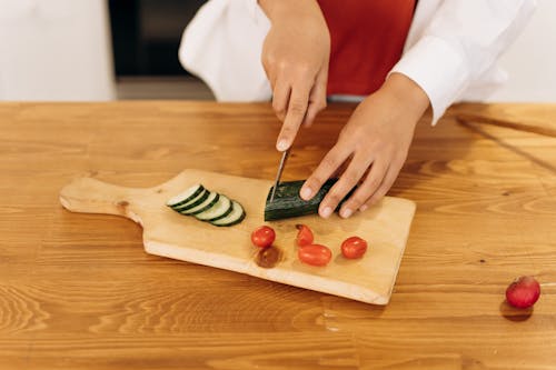 Woman Slicing A Cucumber