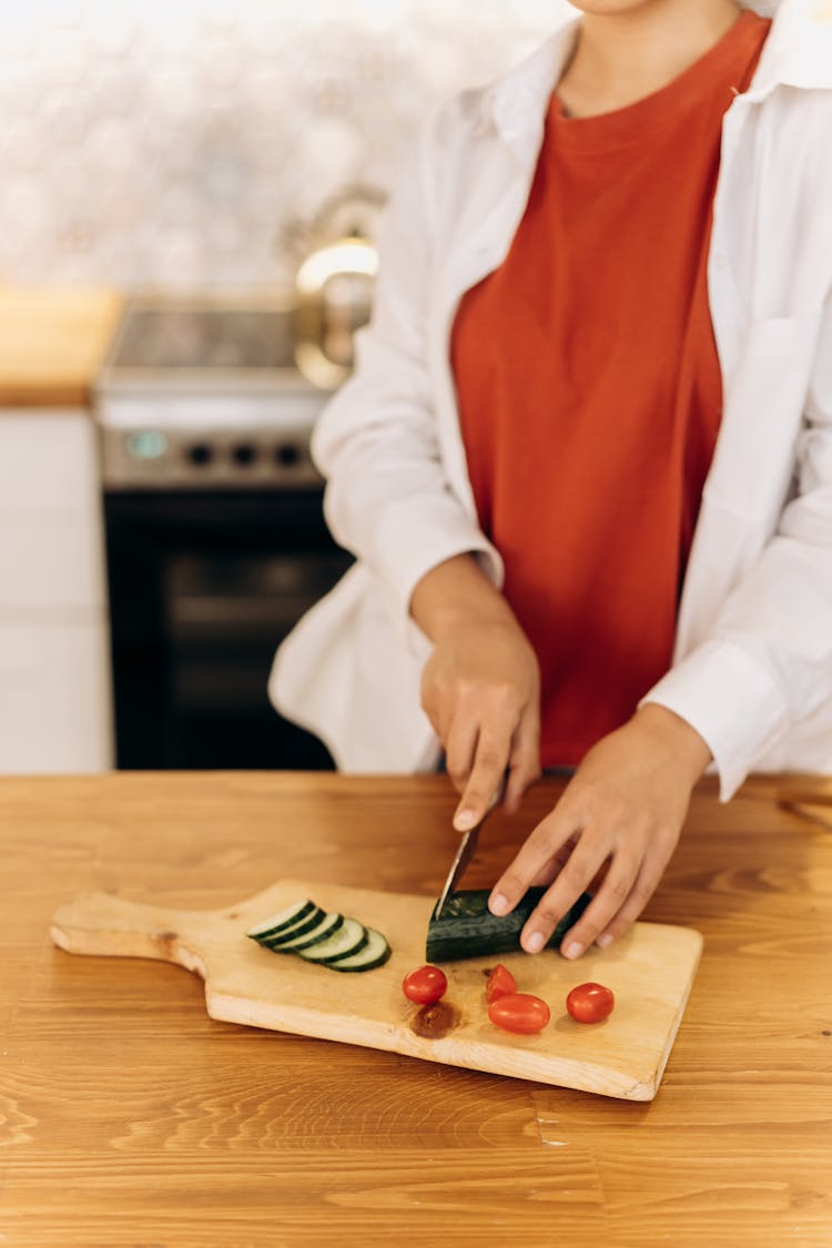 Woman Slicing A Cucumber