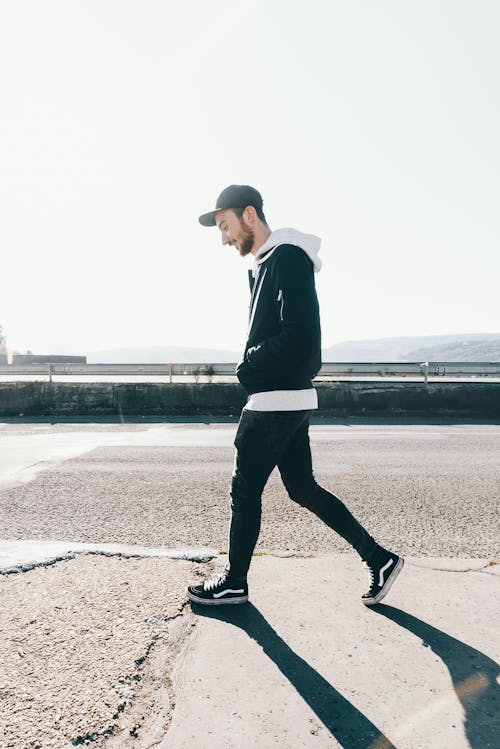 Man Walking on Road Under the Sun