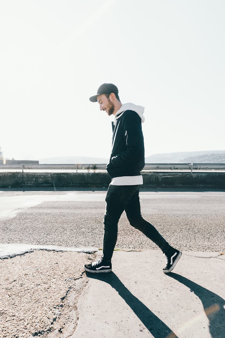 Man Walking On Road Under The Sun