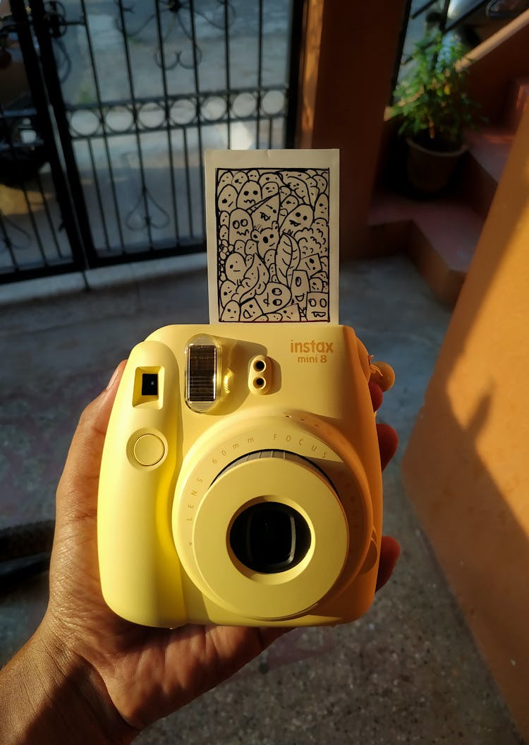 Close-Up Shot Of A Person Holding A Yellow Polaroid Camera