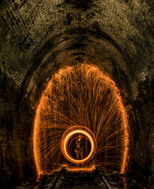 Free Vibrant steel wool light painting in an abandoned tunnel at night. Stock Photo