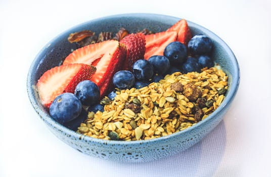 Delicious granola bowl topped with fresh strawberries and blueberries, perfect for a healthy breakfast.
