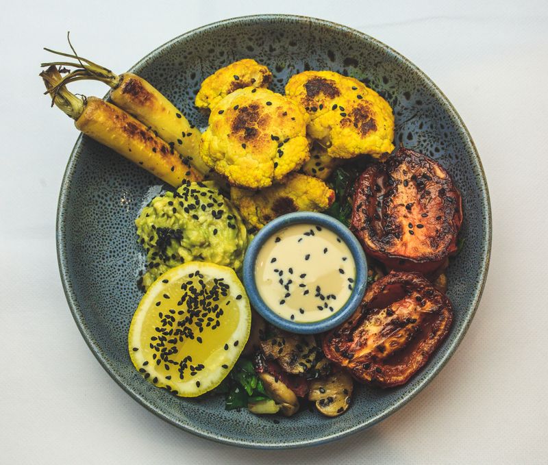 Roasted cauliflower bowl with tahini and charred tomato — photo by Macourt Media on Pexels