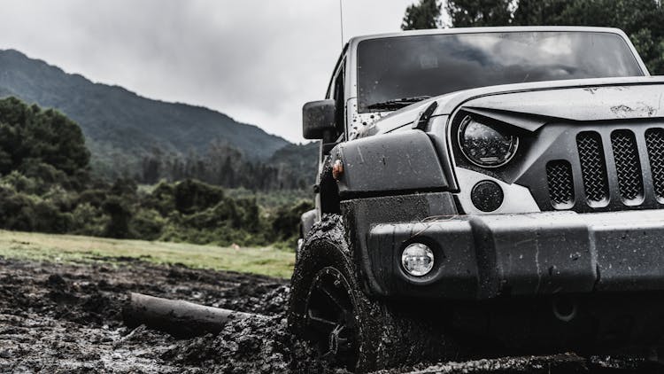 A Jeep Driving On Muddy Road