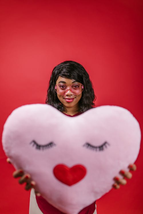 Woman Holding a Pink Heart Shaped Pillow