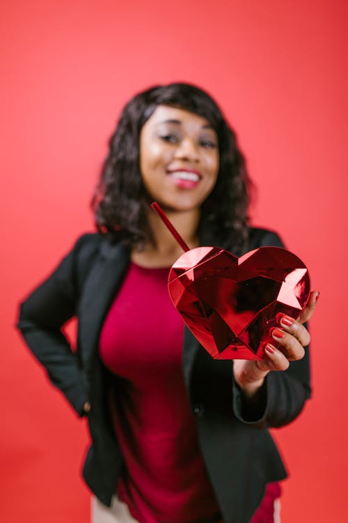 Woman Holding a Red Heart Shaped Ornament