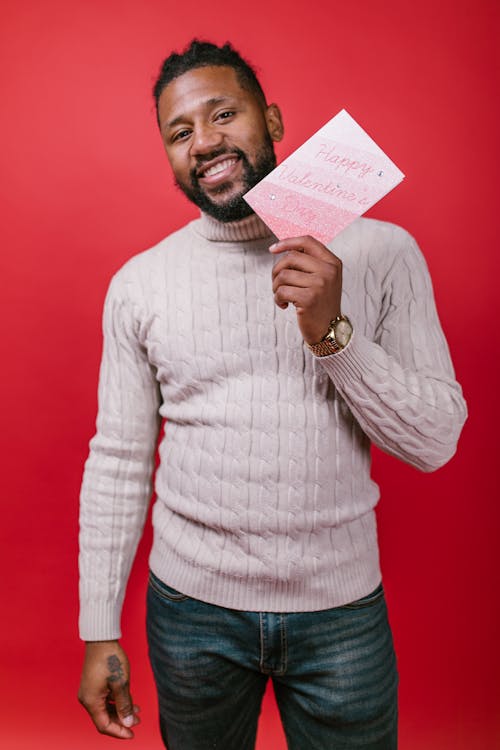 Man in White Sweater Holding a Valentine's Day Card