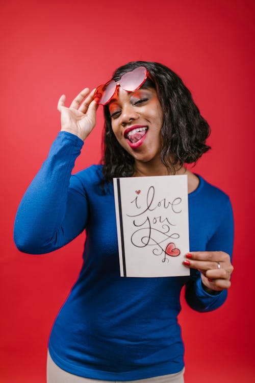 Woman in Blue Long Sleeve Shirt Holding Valentine's Day Card