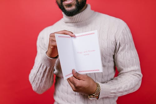 Man in White Sweater Holding a Valentine's Day Card