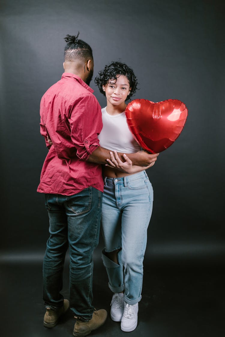 Couple Holding A Red Heart Shaped Balloon