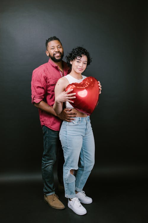 Couple Holding a Red Heart Shaped Balloon