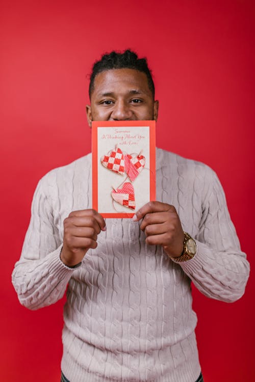 Man in White Sweater Holding a Valentine's Day Card