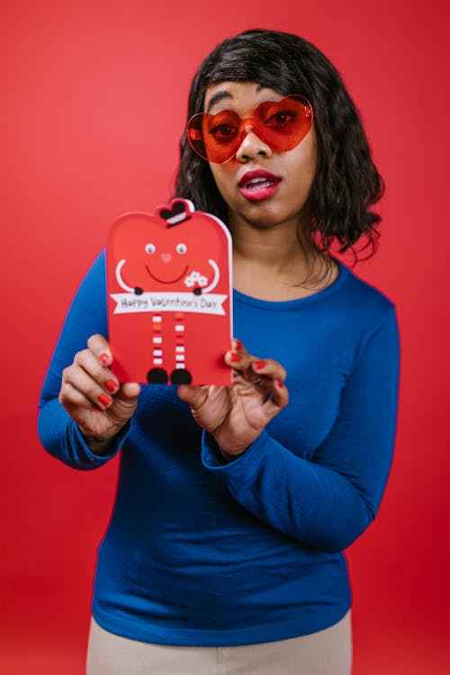 Woman in Blue Long Sleeve Shirt Holding Valentine's Day Card